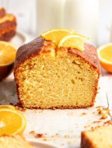 Orange pound cake cut open with a slice of orange on top.