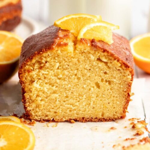 Orange pound cake cut open with a slice of orange on top.