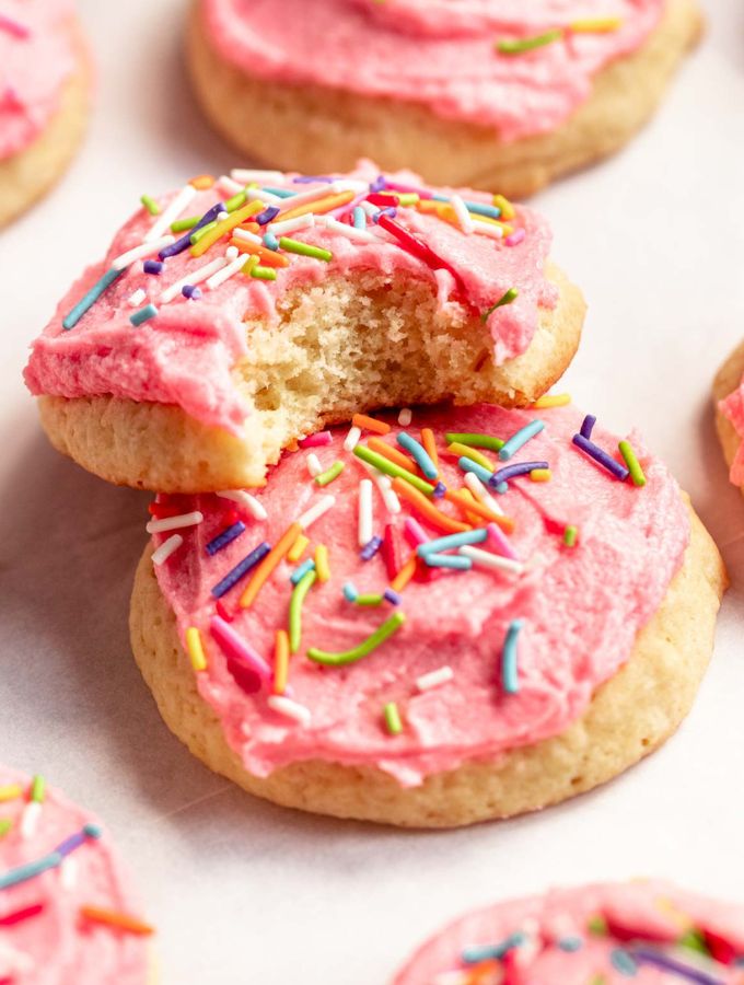 Sour cream cookies with the top one missing a bite.