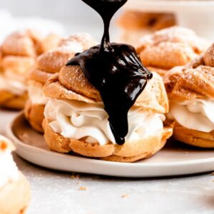 Close up shot of chocolate covered cream puffs.