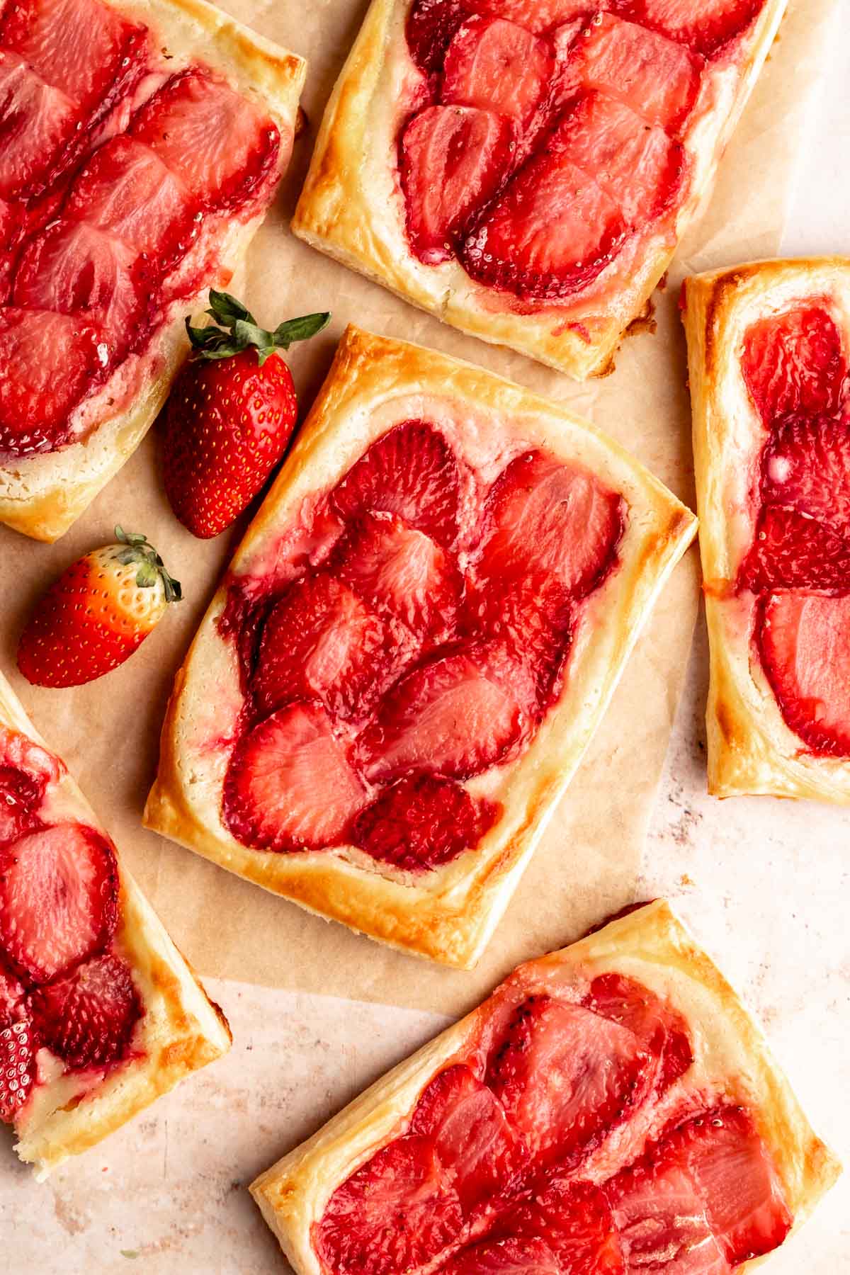 Top of strawberry cream cheese danish on a brown parchment paper.