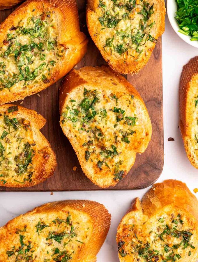 Top of air fryer garlic bread on a wooden board.