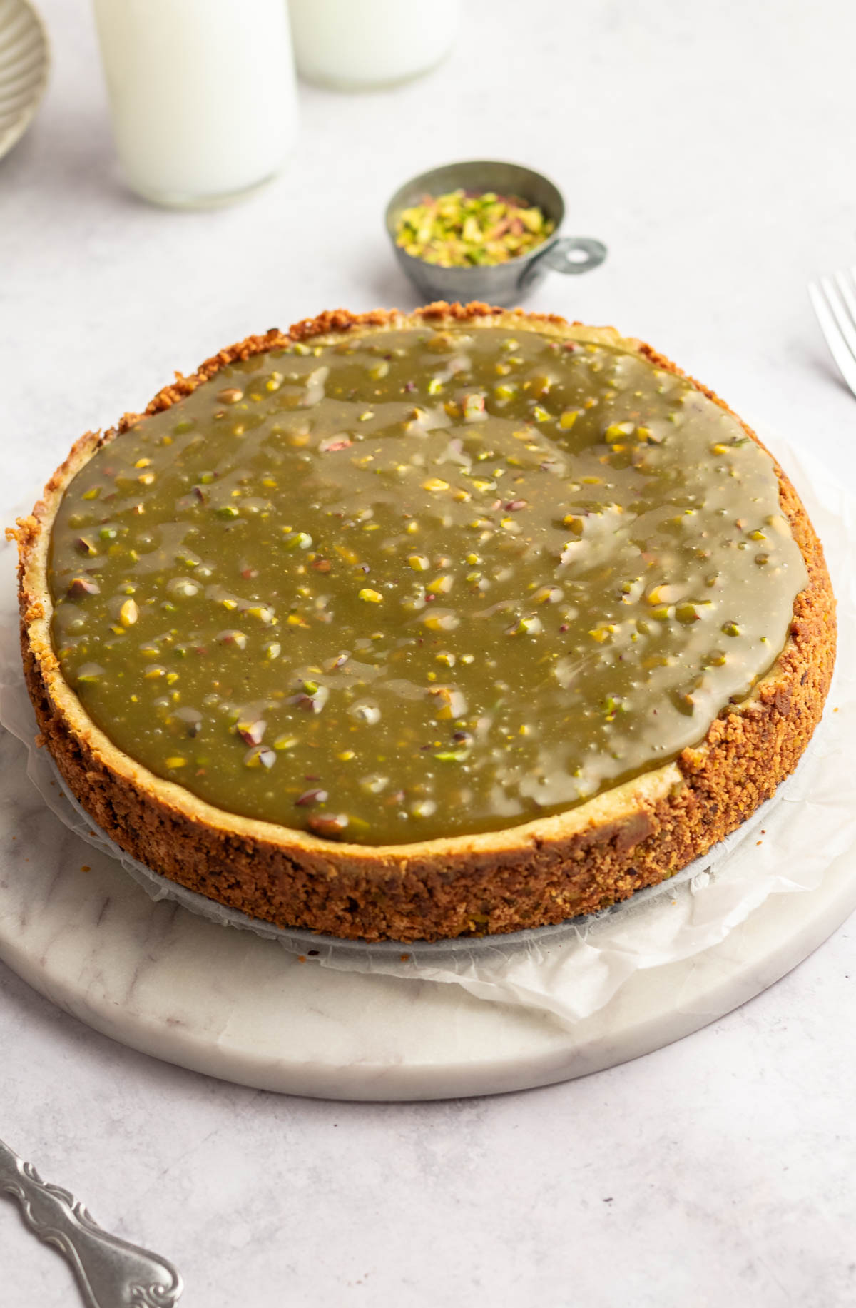 Pistachio cheesecake on a cake plate.