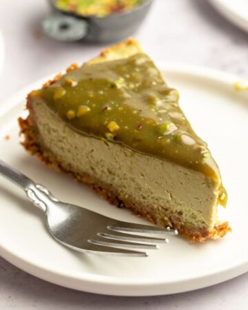 Slice of pistachio cheesecake on a plate.