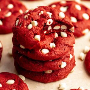 Stack of red velvet cookies with cake mix with a bite missing from the top cookie.