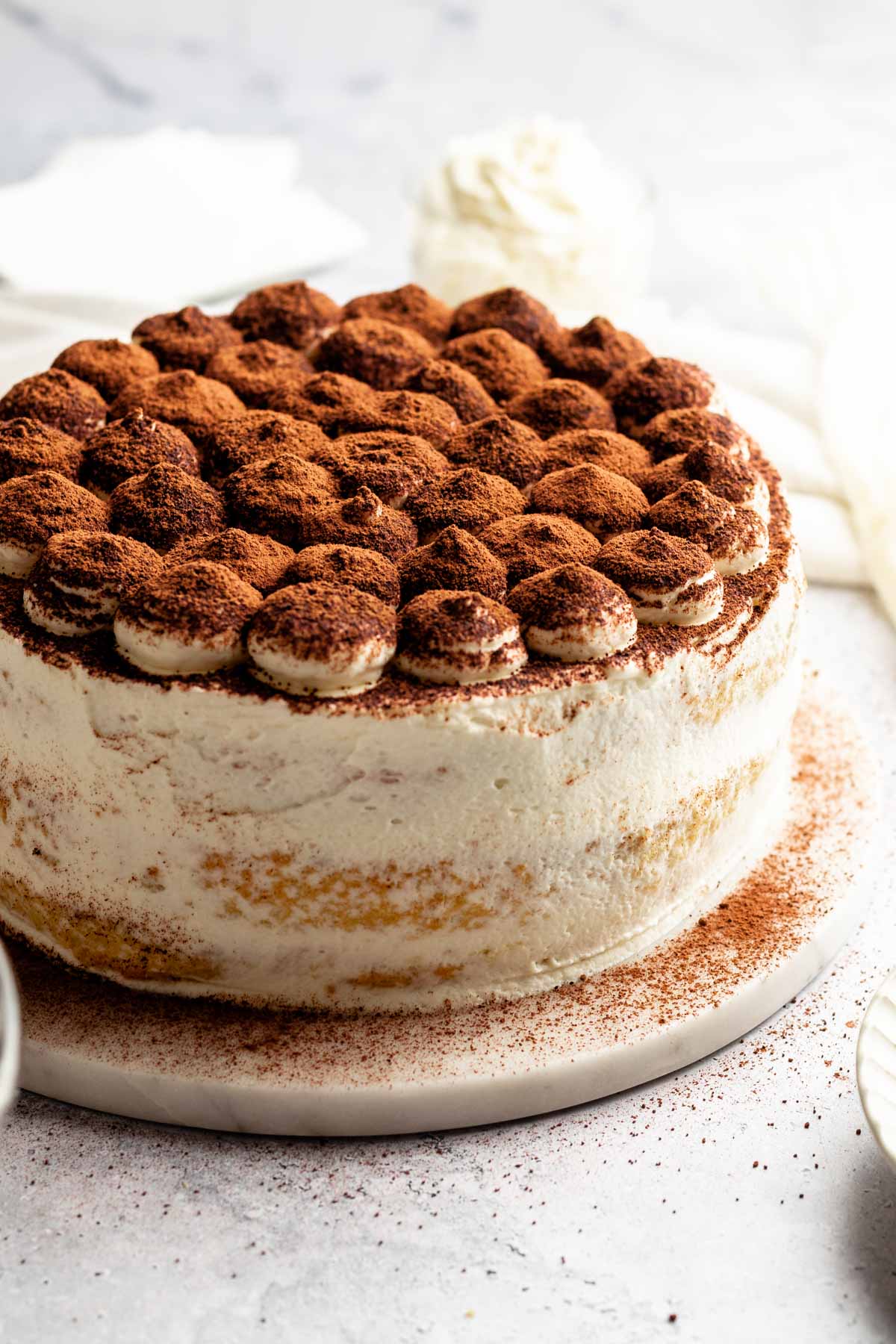 Tiramisu cake on a cake platter.