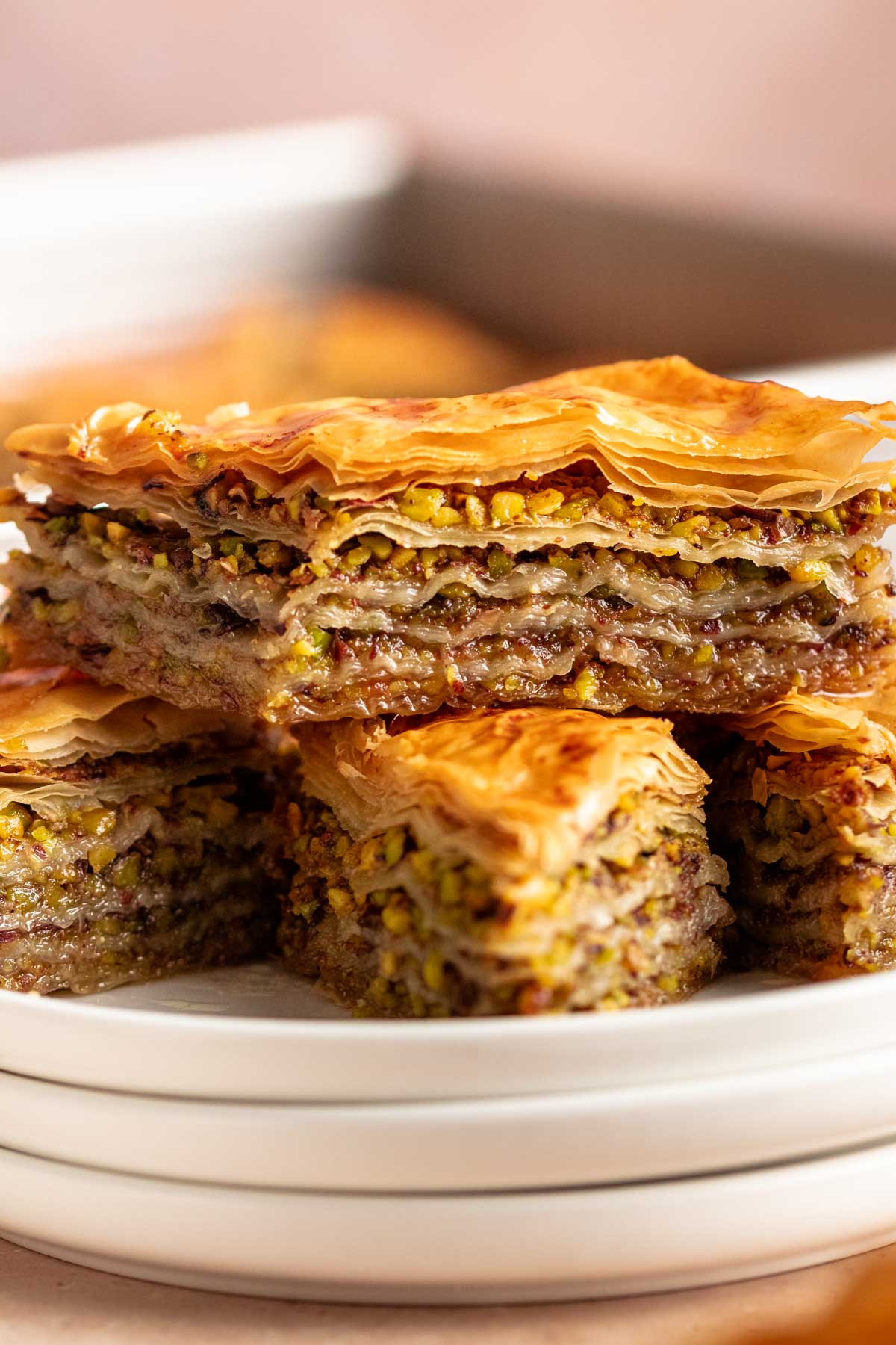 Close up shot of a stack of baklava on a white plate.