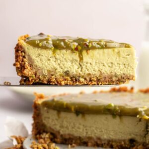 Close up shot of a slice of pistachio cheesecake.