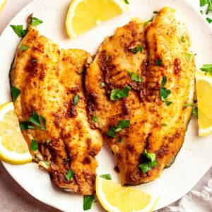 Top of air fryer tilapia on a white plate.