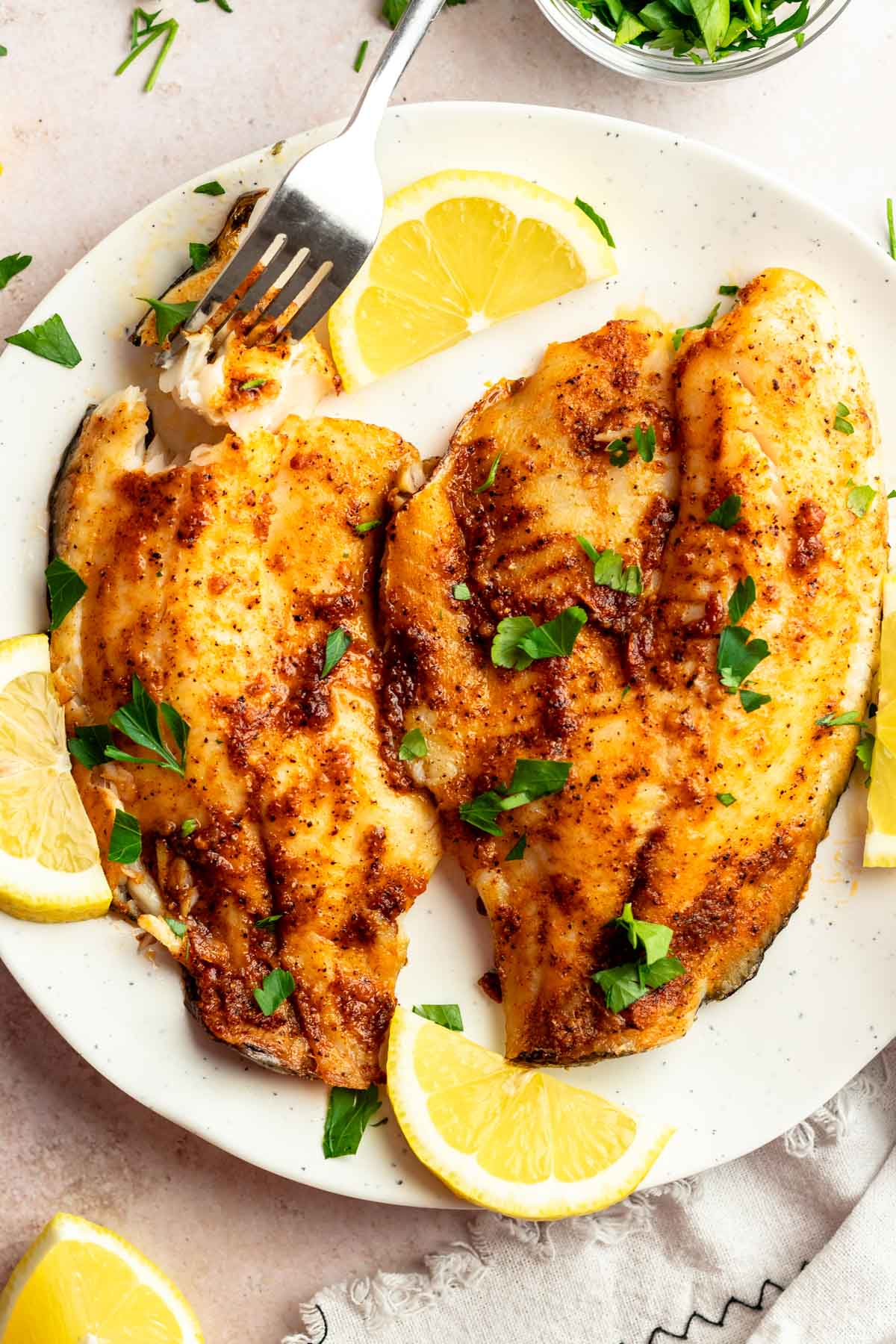 Top of air fryer tilapia on a white plate.