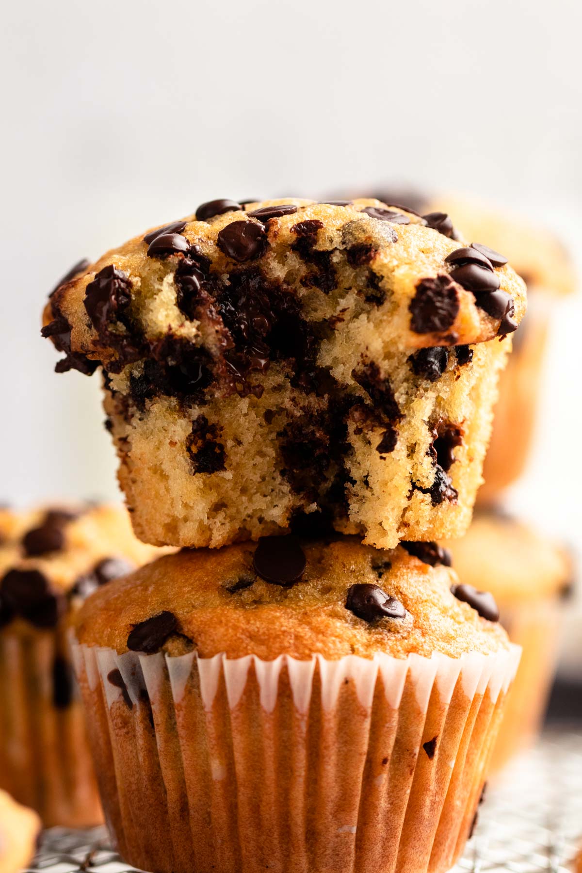 Stack of two muffins with the top one missing a bite.