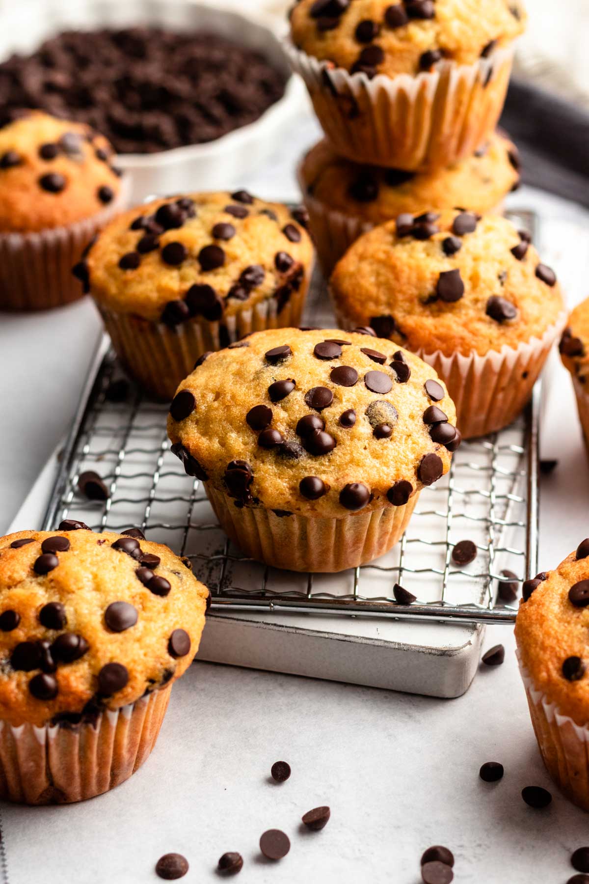 Bakery style muffins with chocolate chips on a cooling rack.