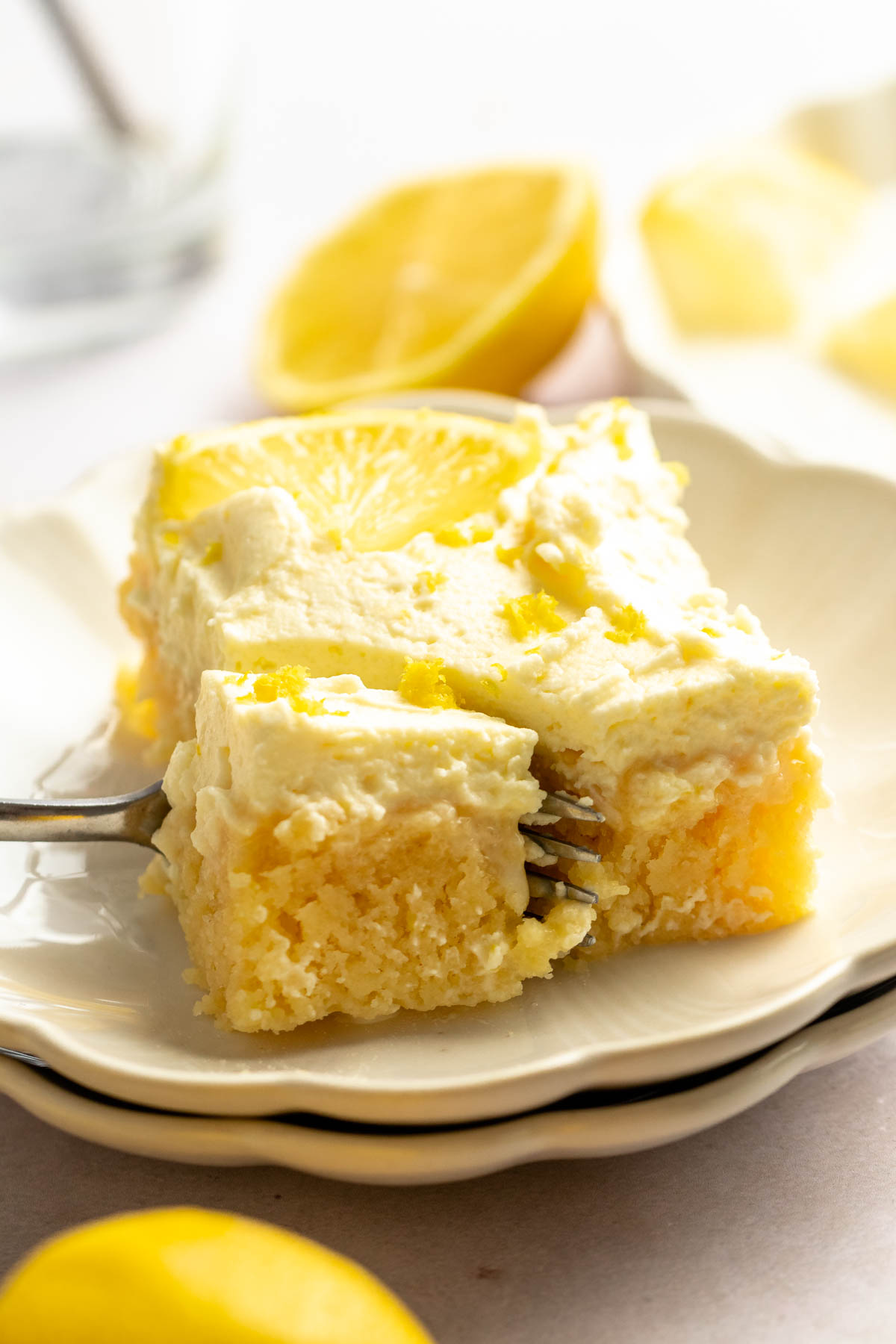 Slice of lemon poke cake on a white plate.