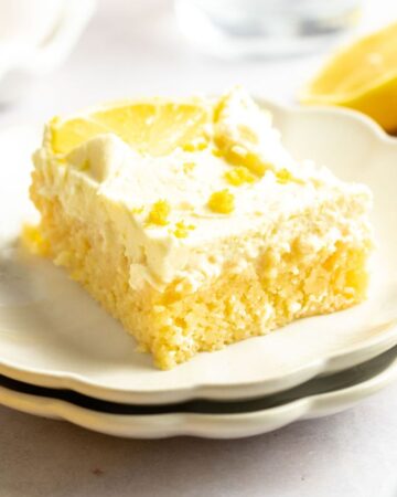 Slice of lemon poke cake on a white plate.
