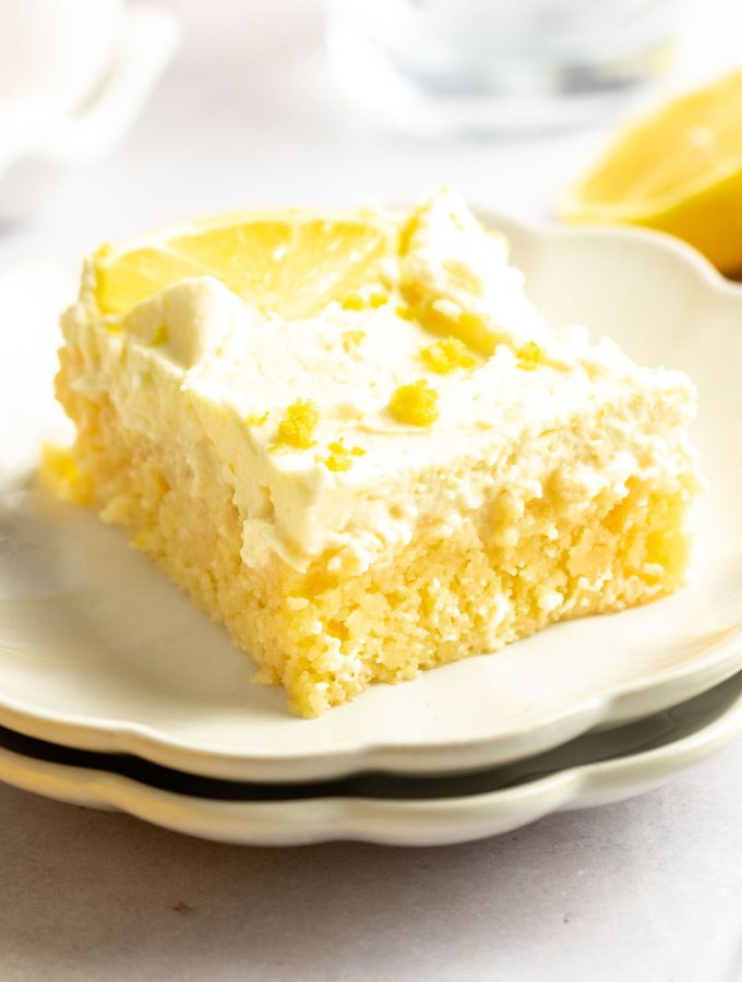 Slice of lemon poke cake on a white plate.