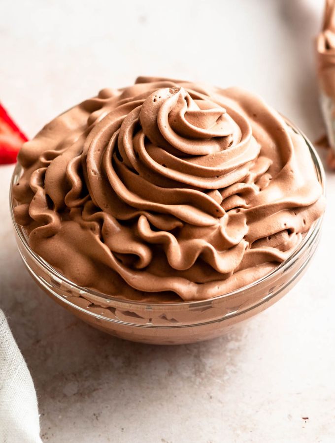 Chocolate whipped cream frosting in a glass bowl.