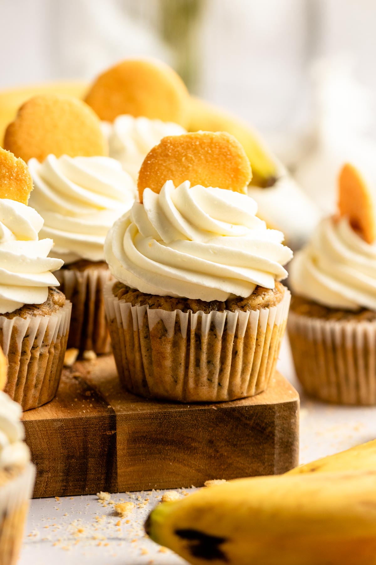 Banana pudding cupcakes on a wooden board.