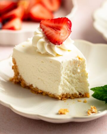Slice of a no bake cheesecake with a strawberry on top.