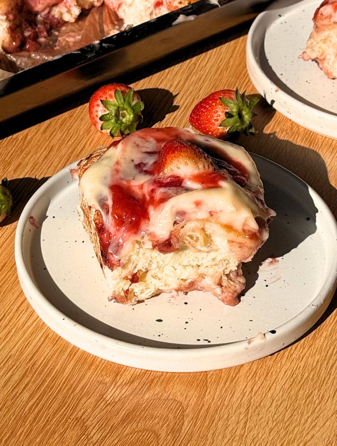 A strawberry cinnamon roll on a plate.