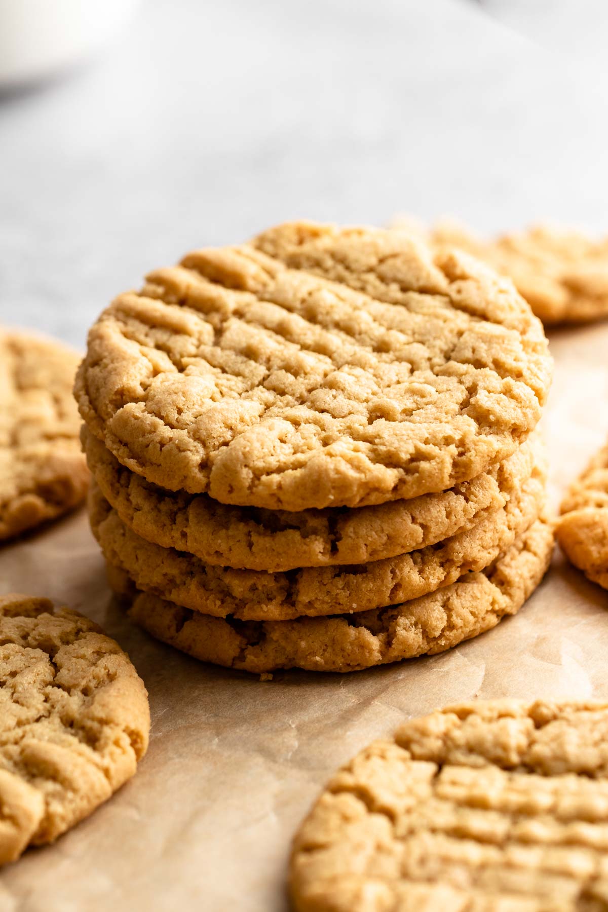 Stack of 4 ingredient peanut butter cookies on a brown parchment paper.