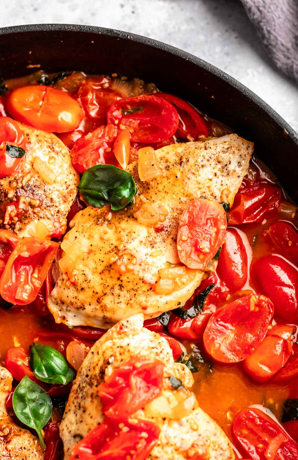 Top of chicken with tomato sauce in a pan.