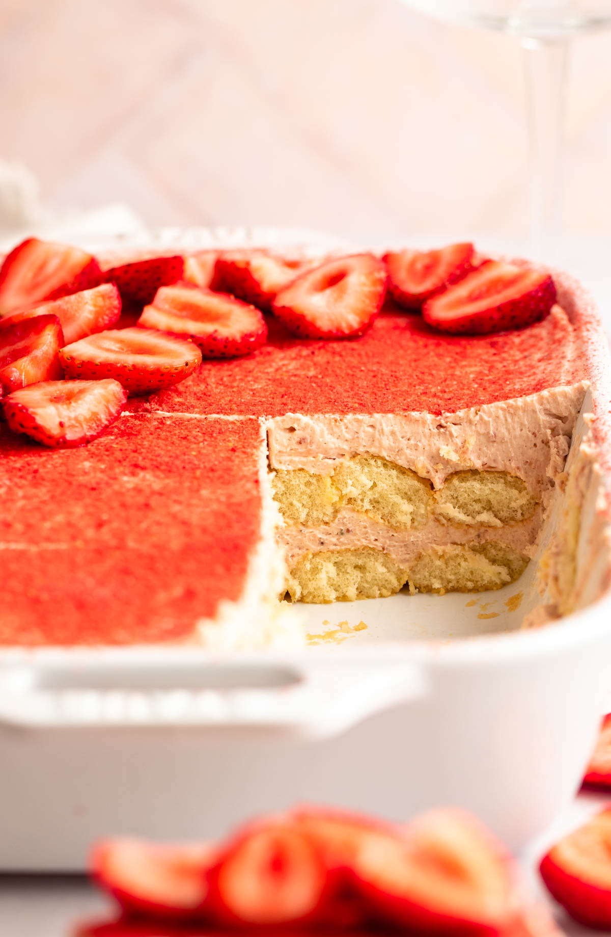 Strawberry tiramisu with a slice missing.