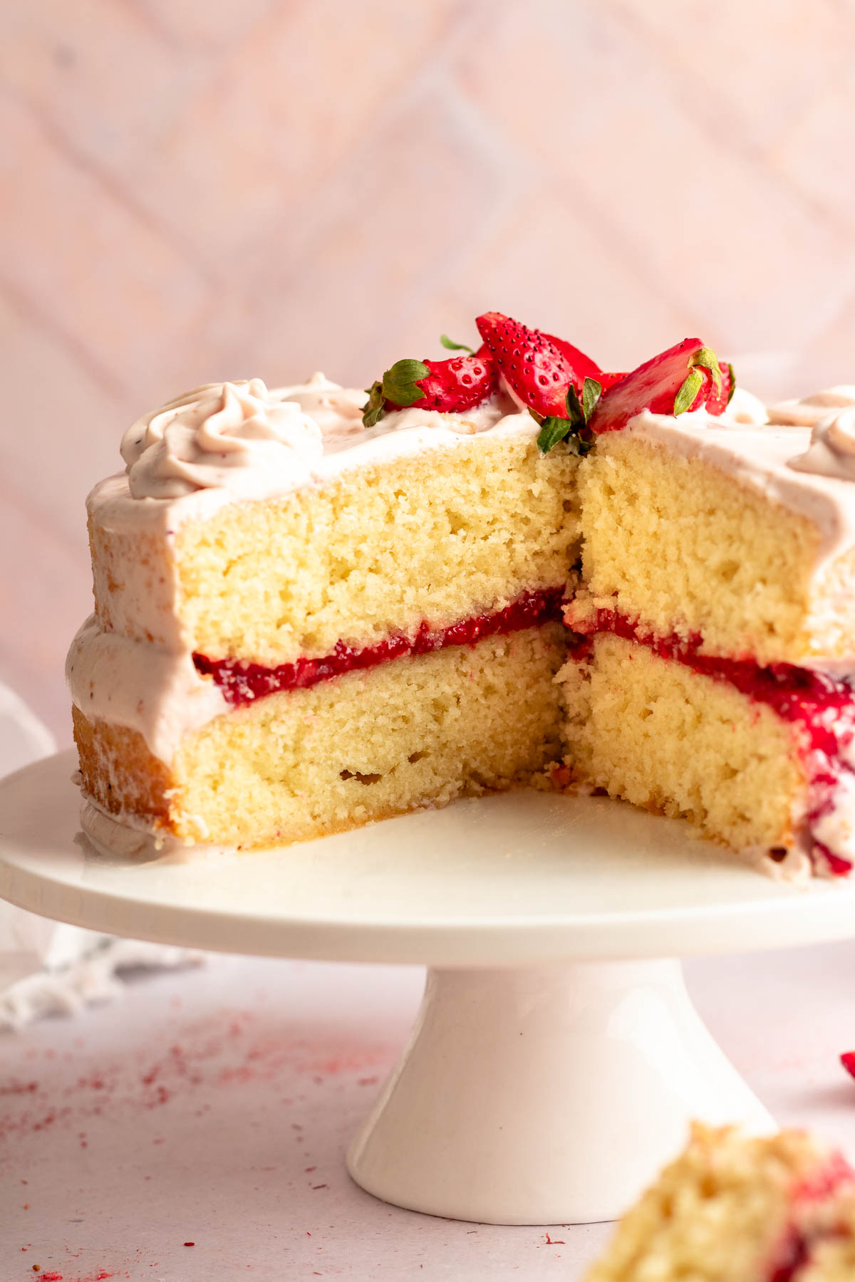 Close up shot of vanilla strawberry cake on a cake plate.