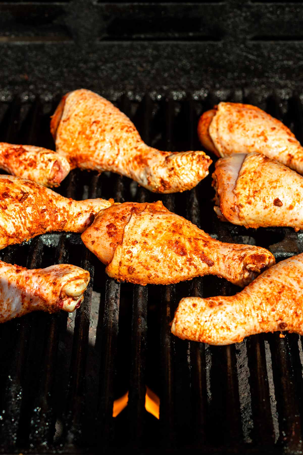 Uncooked chicken legs on a hot grill.
