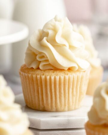 Close up of vanilla cupcakes with vanilla buttercream frosting.