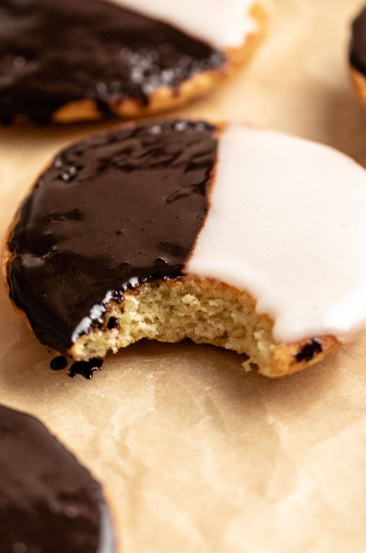 Close up of half moon cookie with a bite missing.