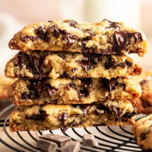 Stack of bakery style chocolate chip cookies cut in half.