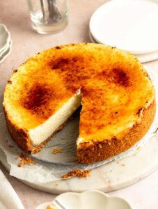 Slice missing from a creme brulee cheesecake.