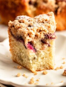 Slice of cherry coffee cake with a bite missing.
