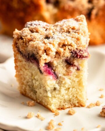Slice of cherry coffee cake with a bite missing.