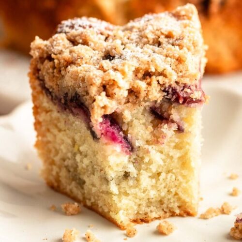Slice of cherry coffee cake with a bite missing.