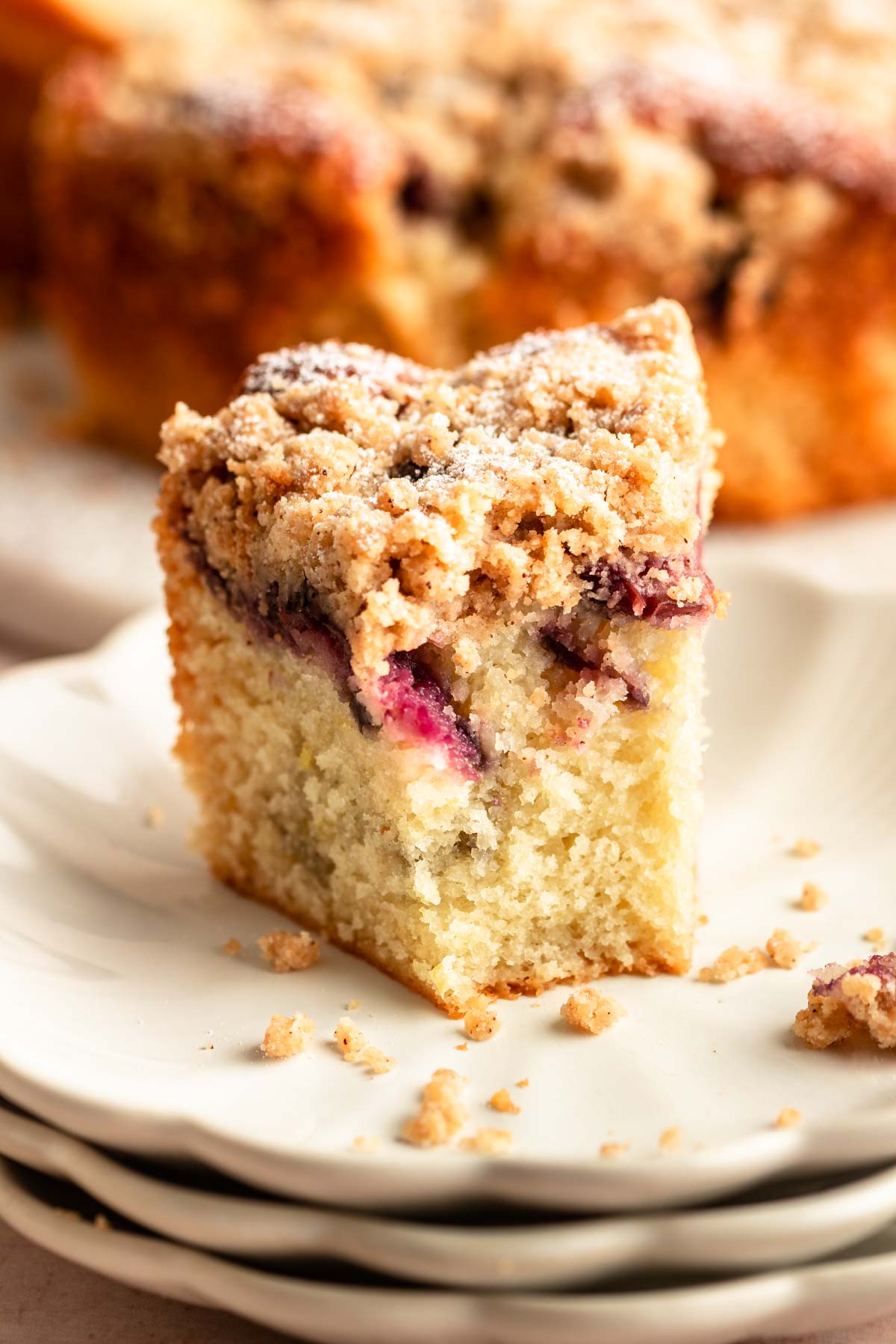 Slice of cherry coffee cake with a bite missing.