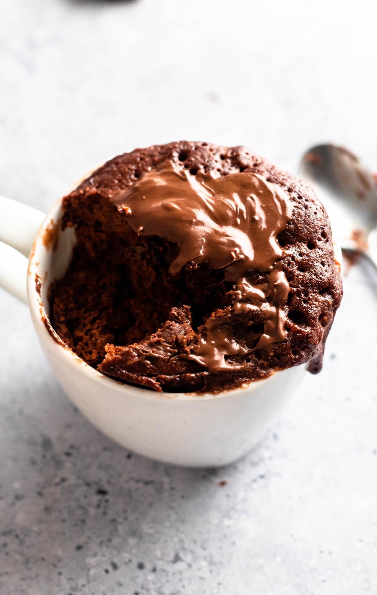 Close up shot of a 3 ingredient chocolate mug cake with a bite missing.