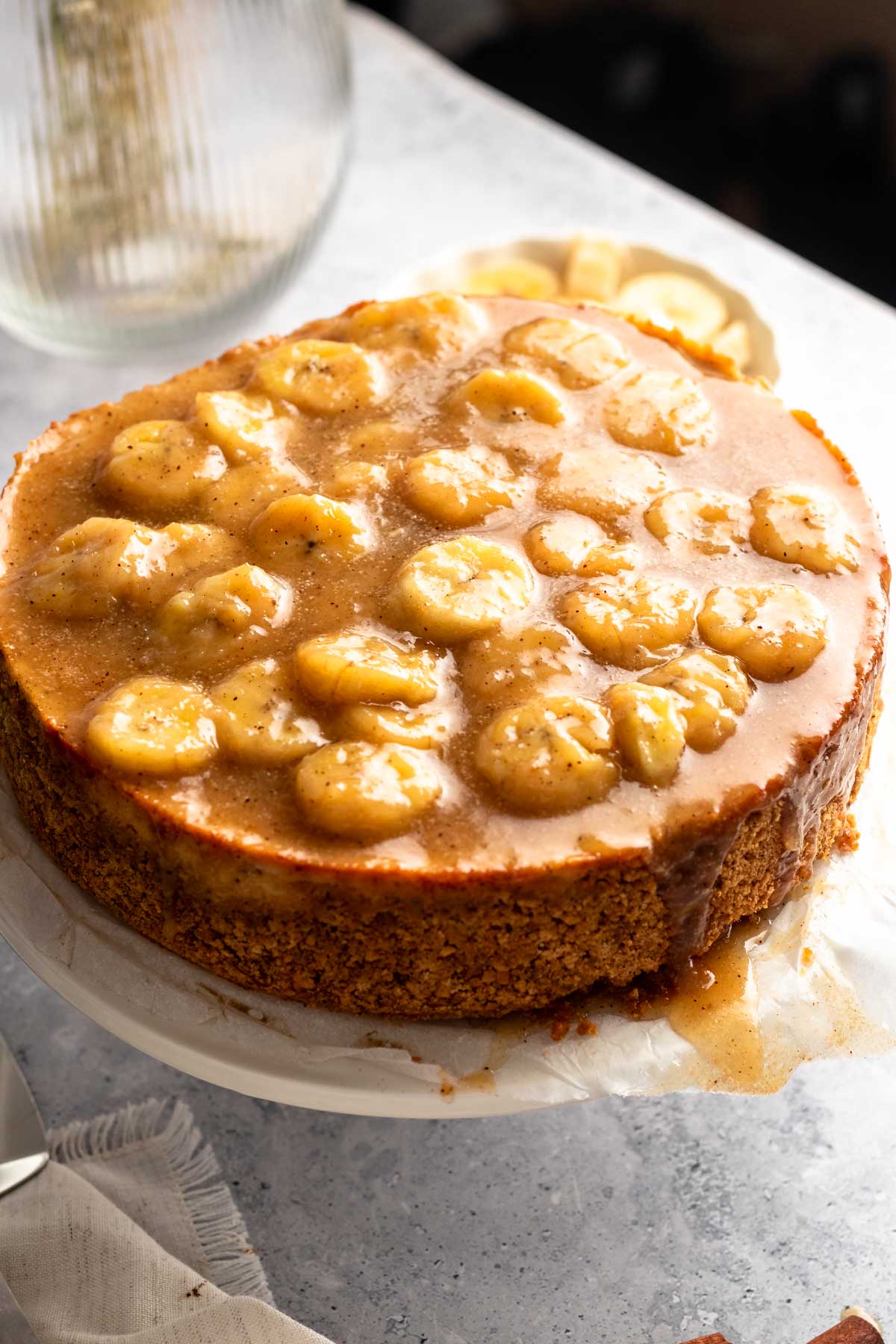 Bananas foster cheesecake on a cake plate.
