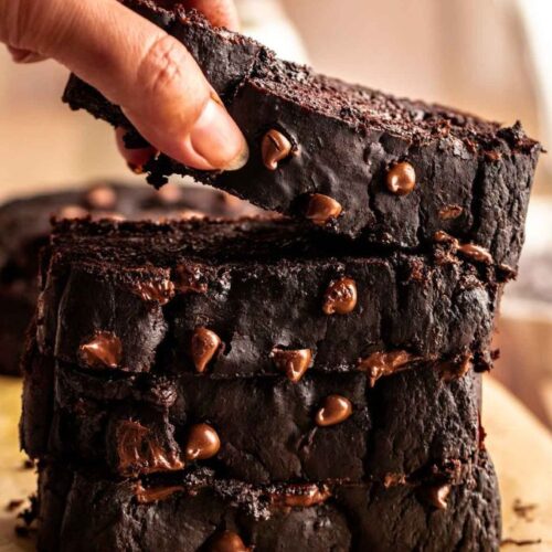 Stack of chocolate pumpkin bread slices with the top one lifted.