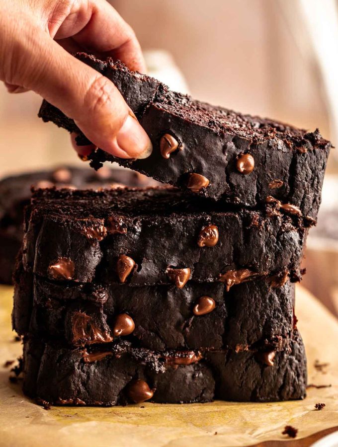 Stack of chocolate pumpkin bread slices with the top one lifted.