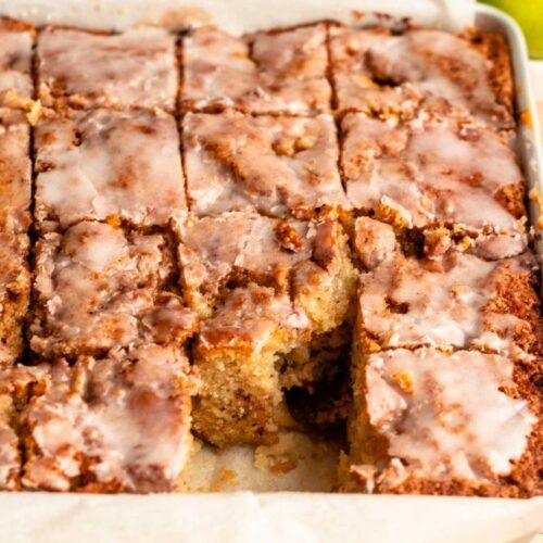 Sliced cinnamon apple cake with a slice missing.