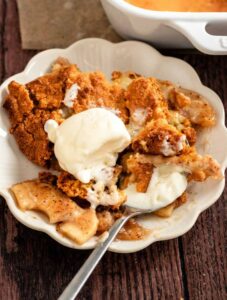 Plate with apple cobbler with cake mix and vanilla ice cream.