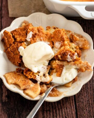 Plate with apple cobbler with cake mix and vanilla ice cream.