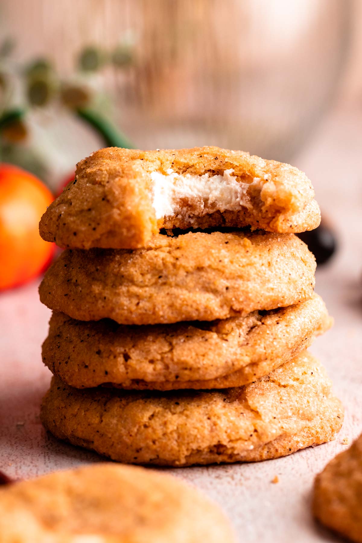 Stack of pumpkin cheesecake cookies with the top one missing a bite.