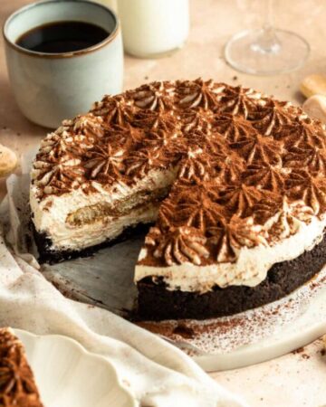 No bake tiramisu cheesecake with a slice missing.