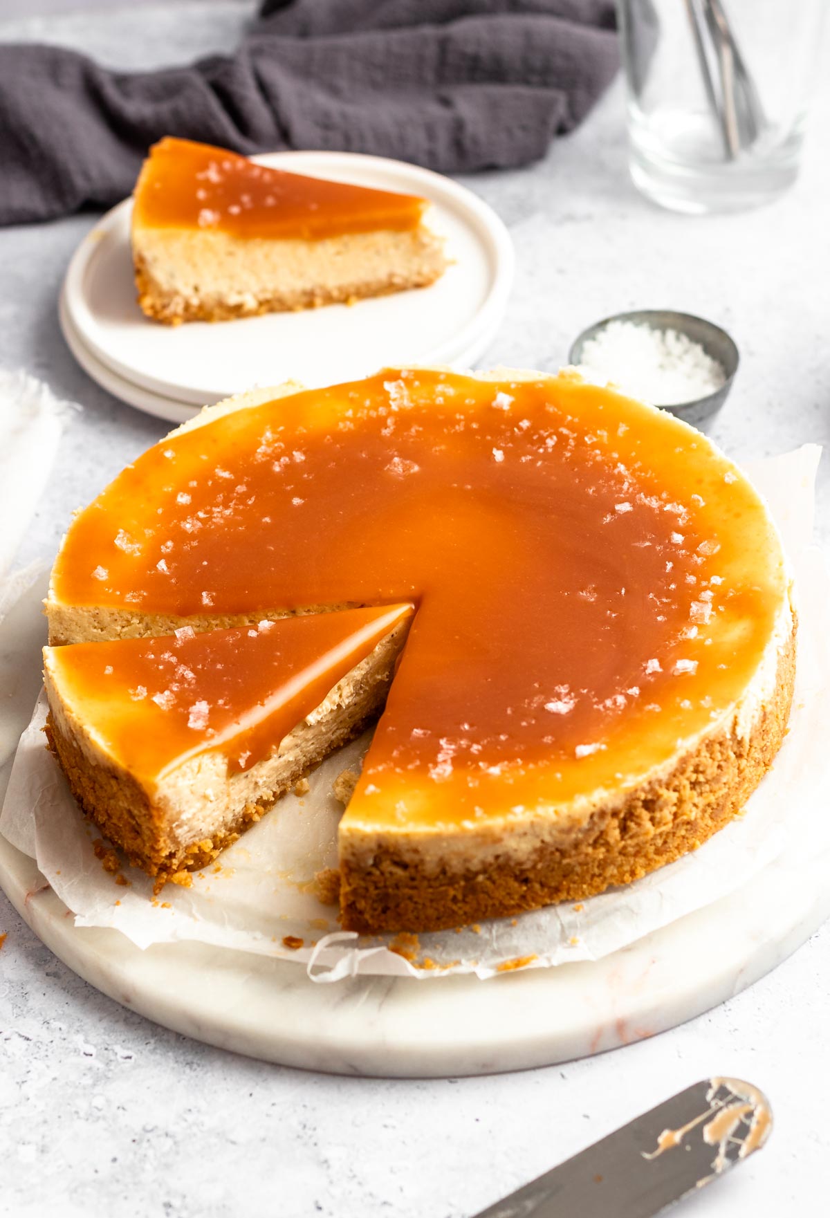 Salted caramel cheesecake sliced on a cake plate.