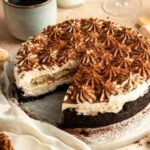 No bake tiramisu cheesecake with a slice missing.
