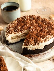 No bake tiramisu cheesecake with a slice missing.