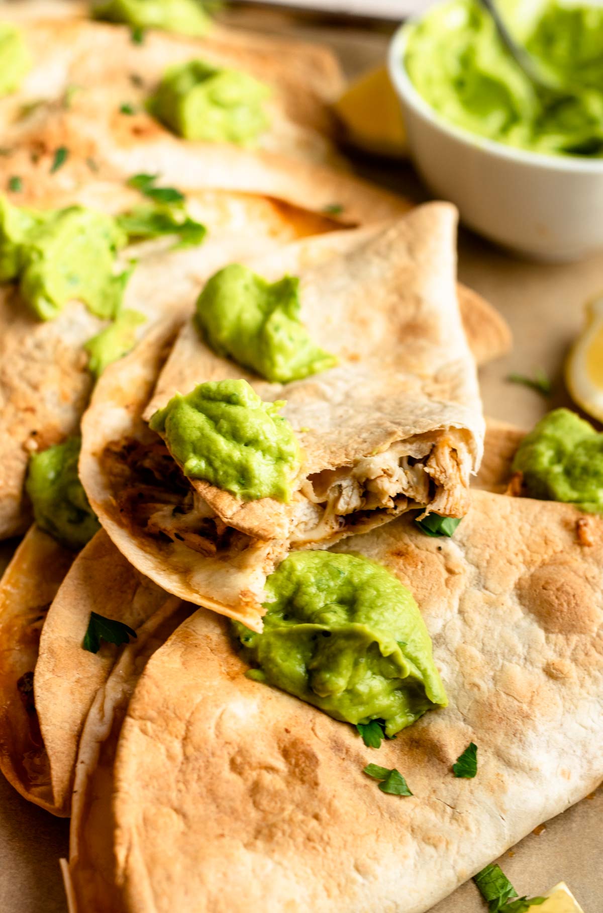 Close up shot of baked chicken tacos with the top one missing a bite.