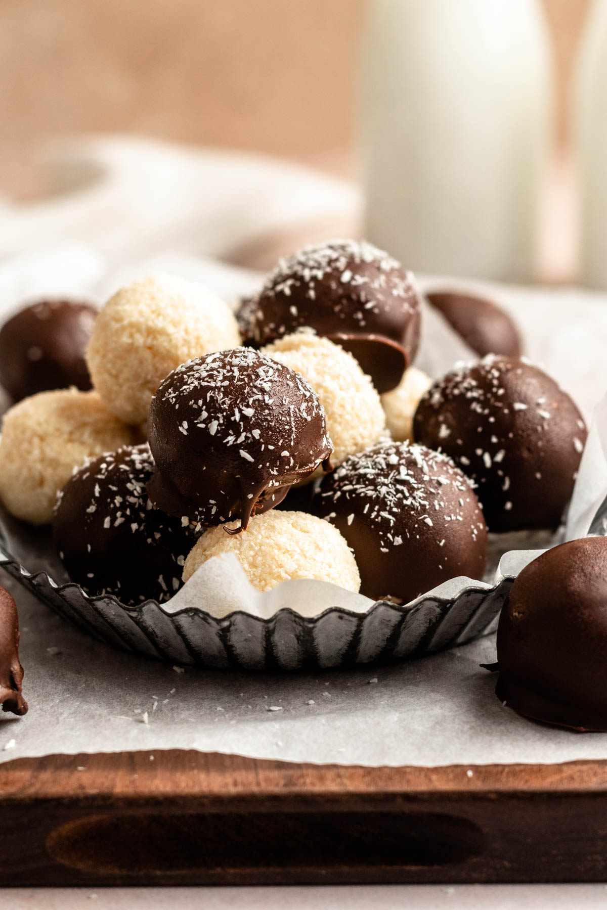 Plate with coconut balls covered in chocolate.